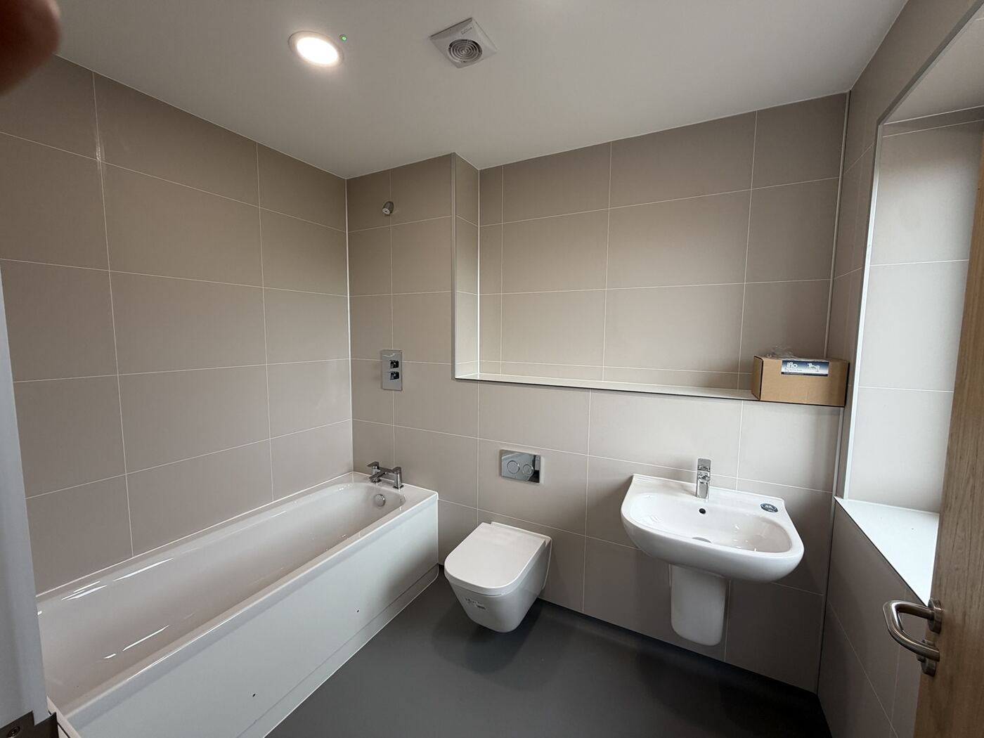 Bathroom with full-height boarded walls and level floor