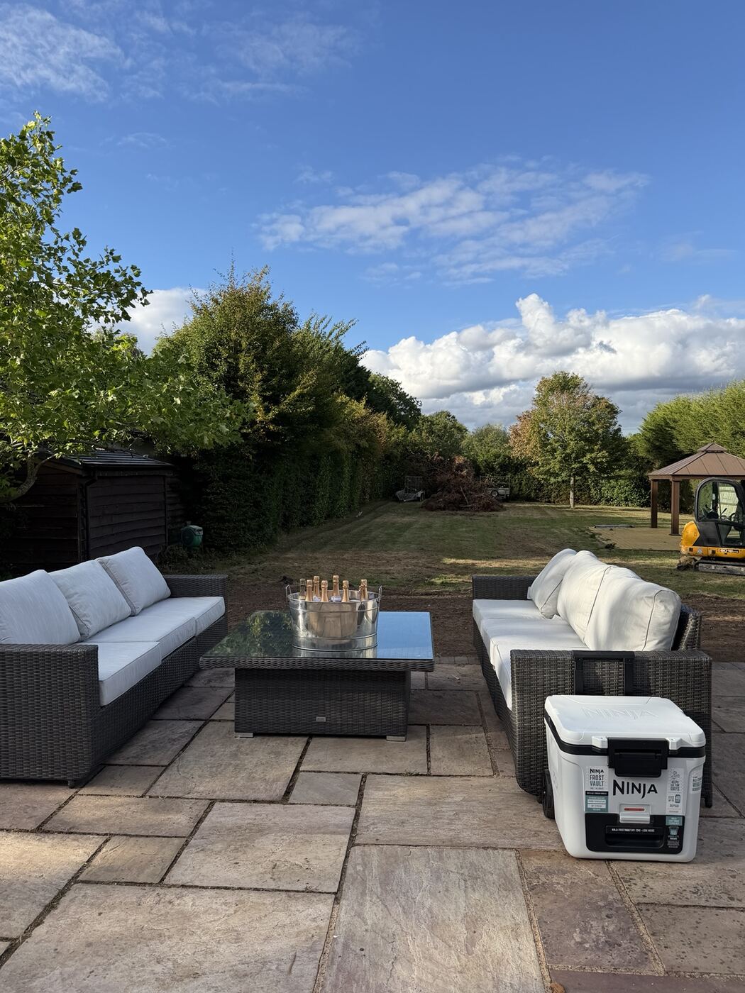 Paved terrace with garden furniture looking over the lawn