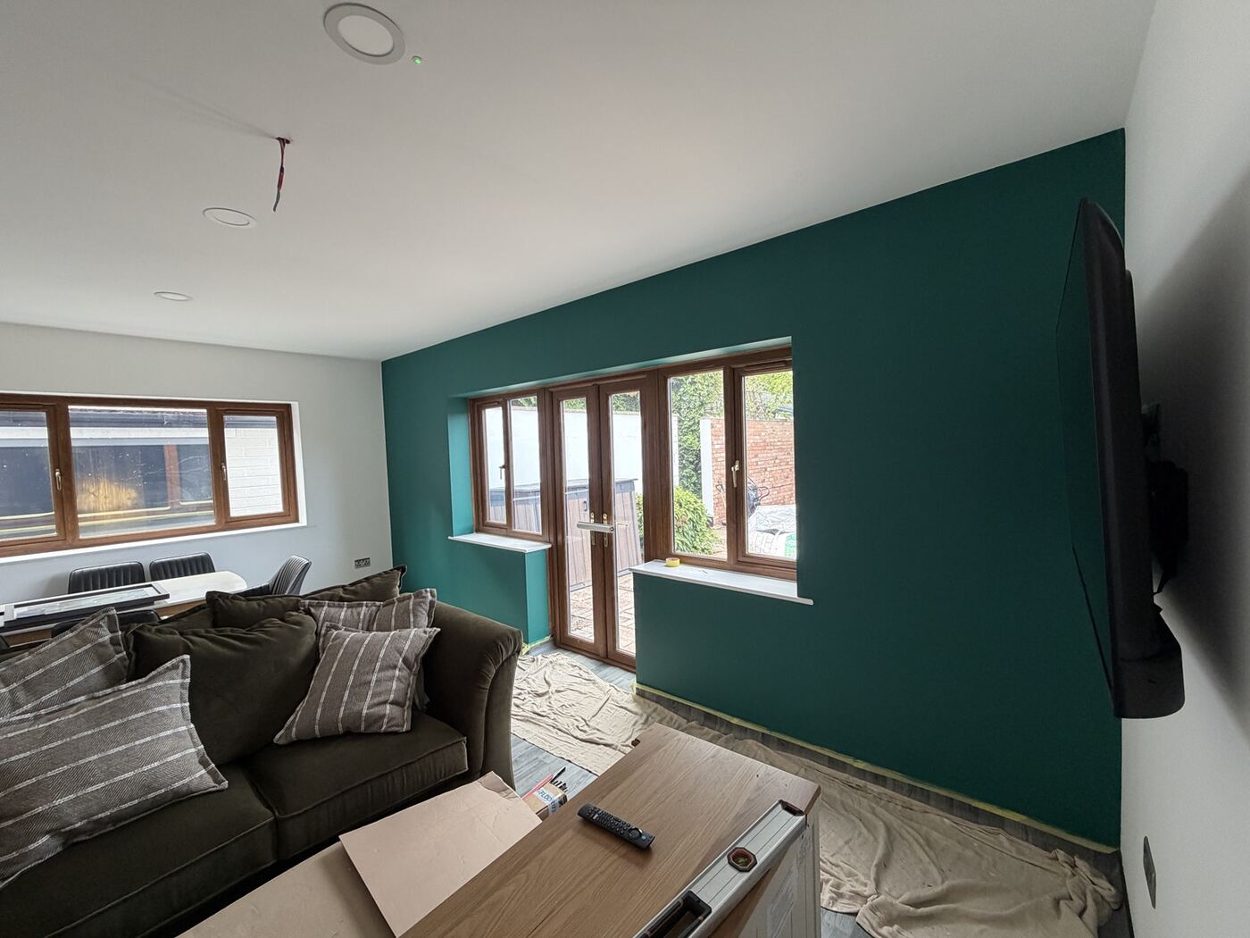 Communal lounge with green feature wall and wall-mounted television