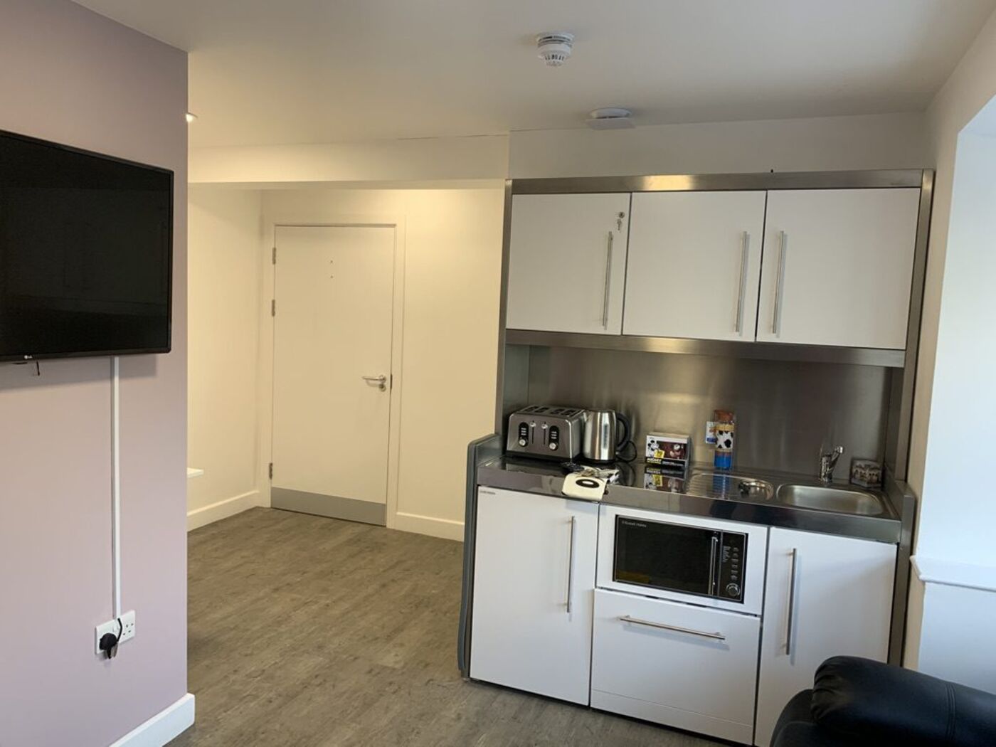 Compact stainless steel kitchenette in a resident suite